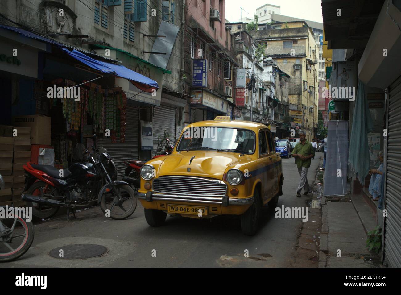 Un taxi giallo che attraversa una strada stretta a Kolkata, Bengala Occidentale, India (2013). I taxi gialli di Kolkata sono ultimamente 'difficilmente visibili per le strade' della città, secondo una pubblicazione di 'Kolkata on Wheels', una rivista mensile di automobilismo e stile di vita. Foto Stock