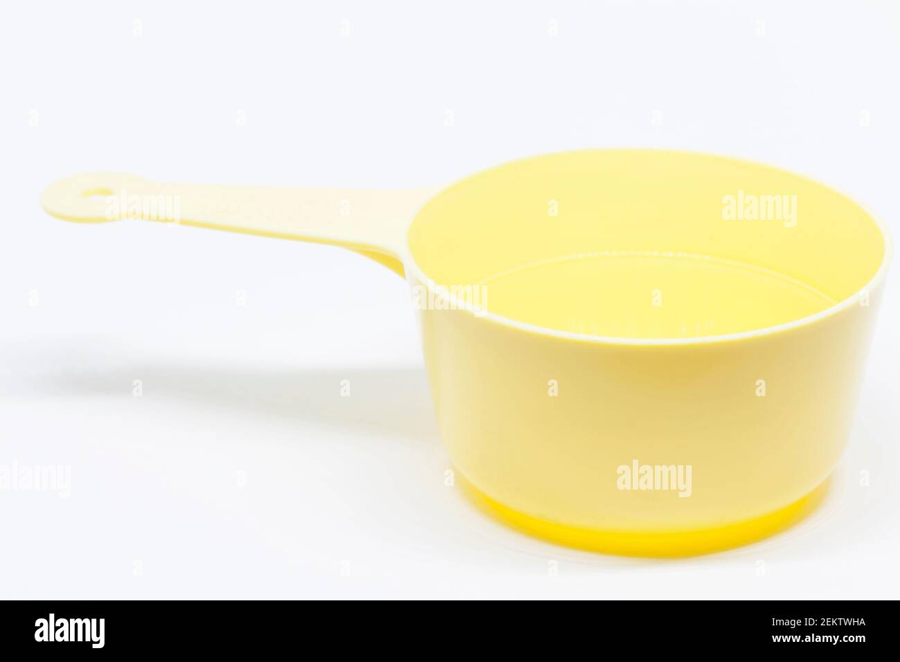 una misura di decilitro giallo su sfondo bianco Foto Stock