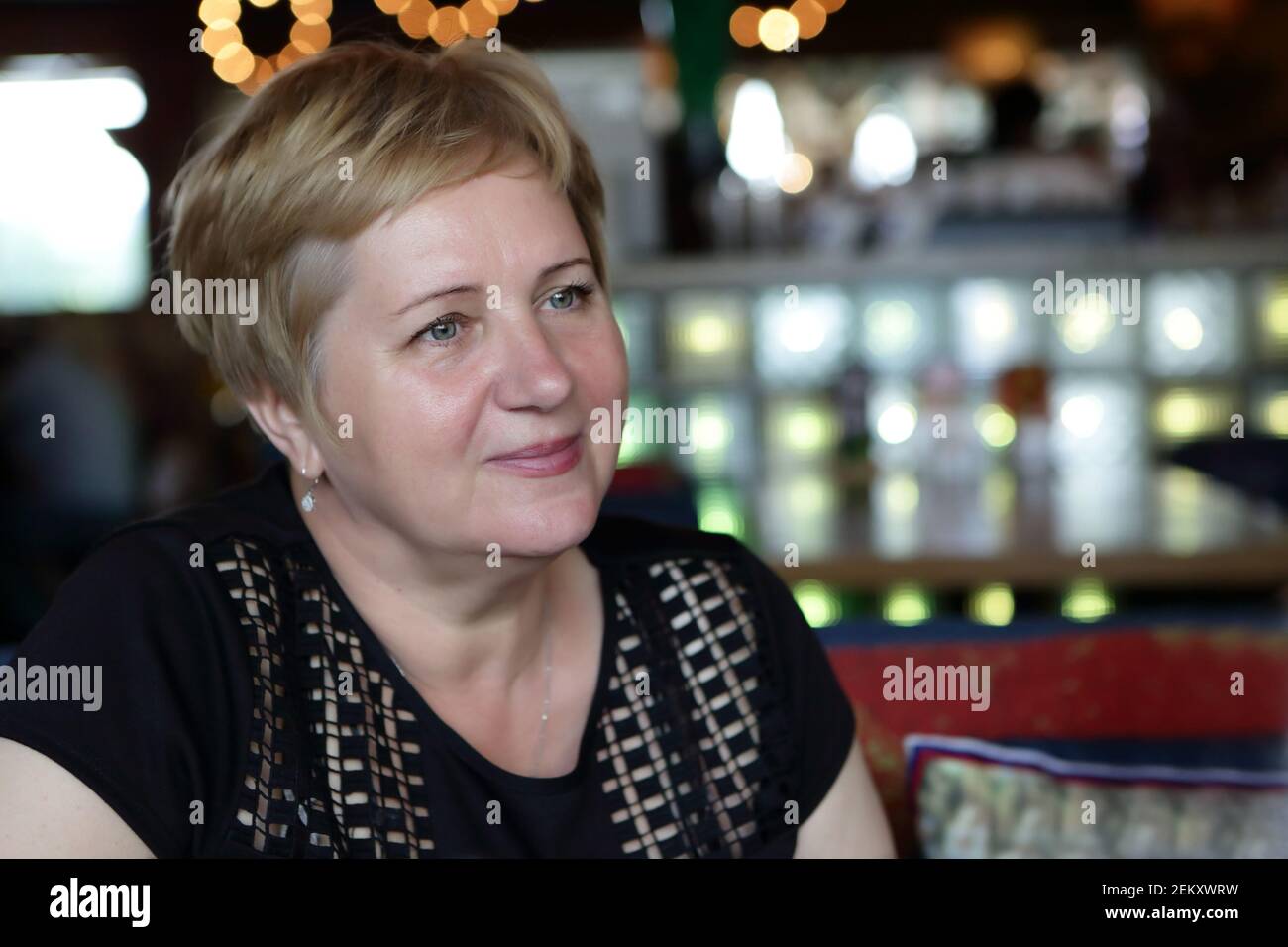 Ritratto di una donna anziana nel bar notturno Foto Stock
