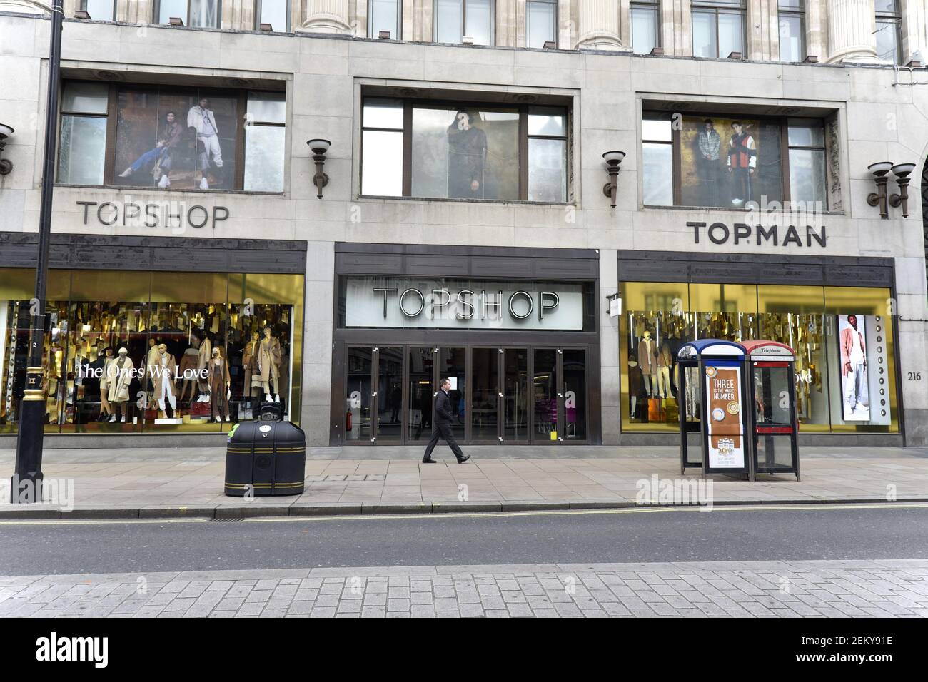 Un uomo solista passa accanto al negozio Topshop and e Topman a Oxford  Street, Londra, un'area solitamente affollata di turisti e acquirenti, ora  vuota quando l'Inghilterra è entrata nel suo secondo blocco. (