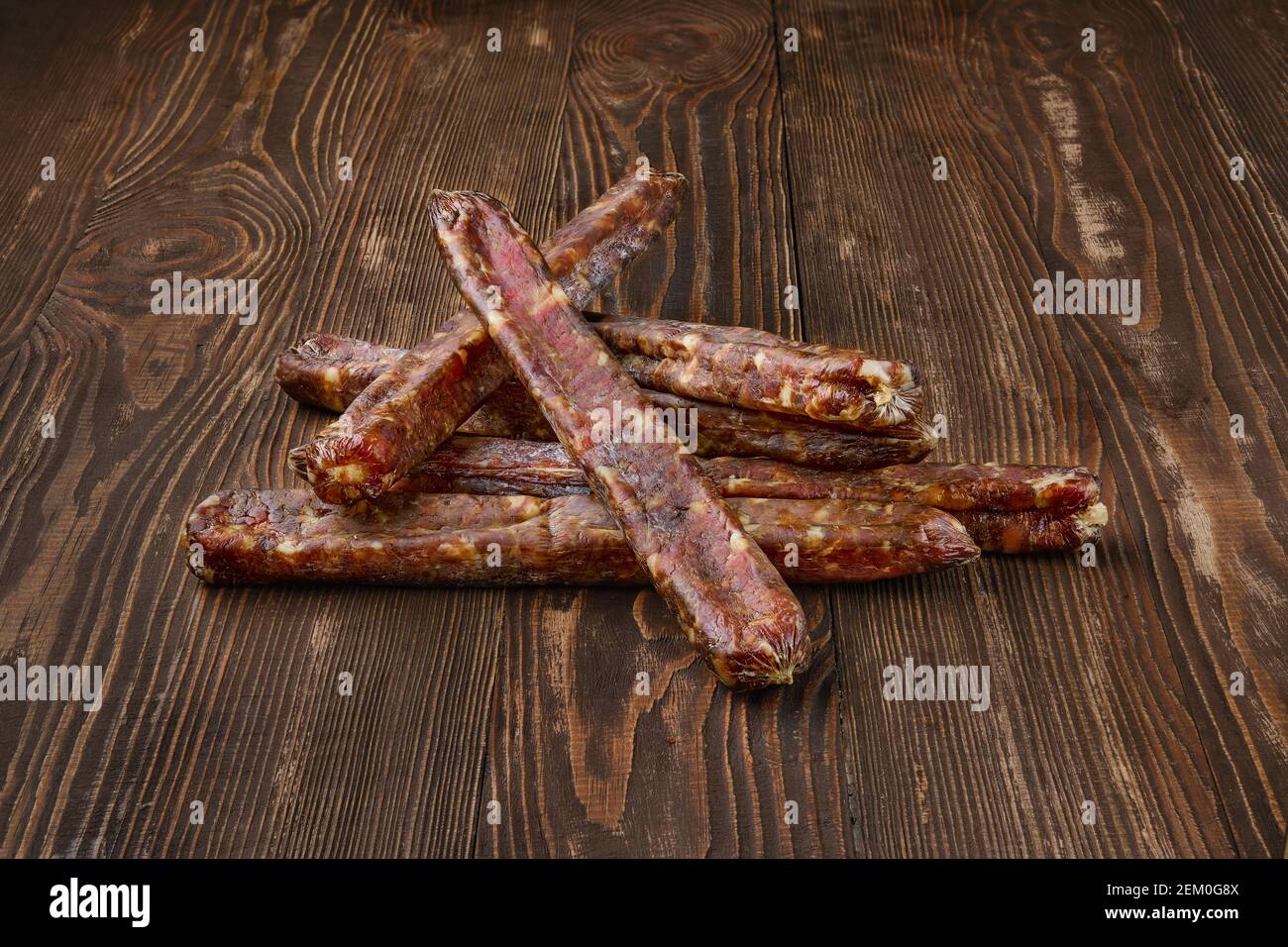 Salsicce di castori fatte in casa e essiccate all'aria su sfondo di legno Foto Stock