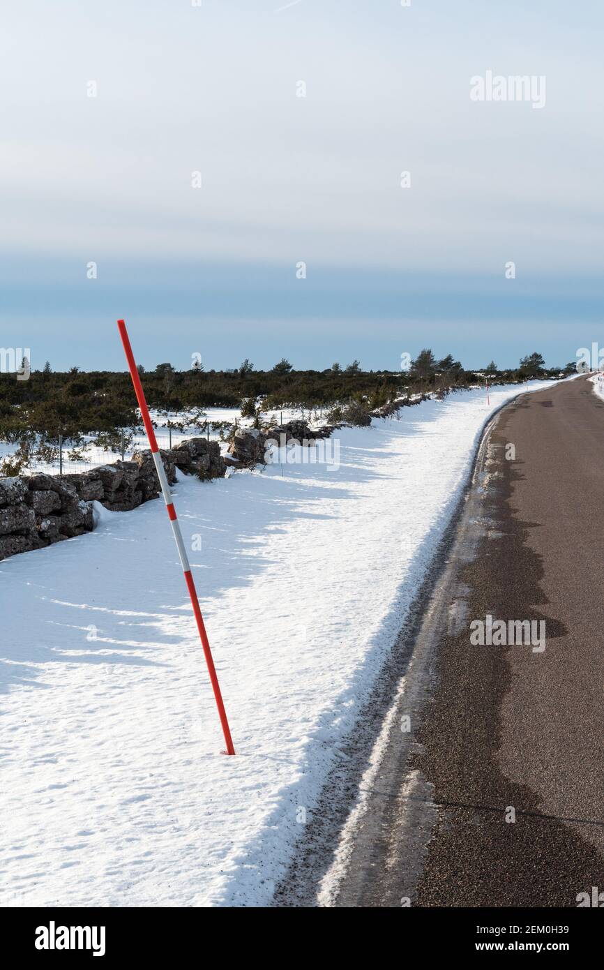 Racchetto di neve rossa sul lato della strada in una tortuosa strada di campagna Foto Stock