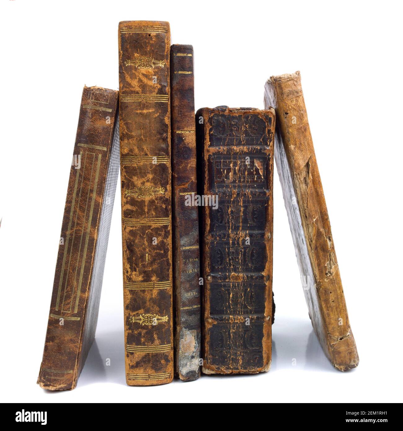 Vecchi libri rilegati in pelle con copertine indossate disposte su uno sfondo bianco che mostra letteratura e manufatti storici d'epoca Foto Stock