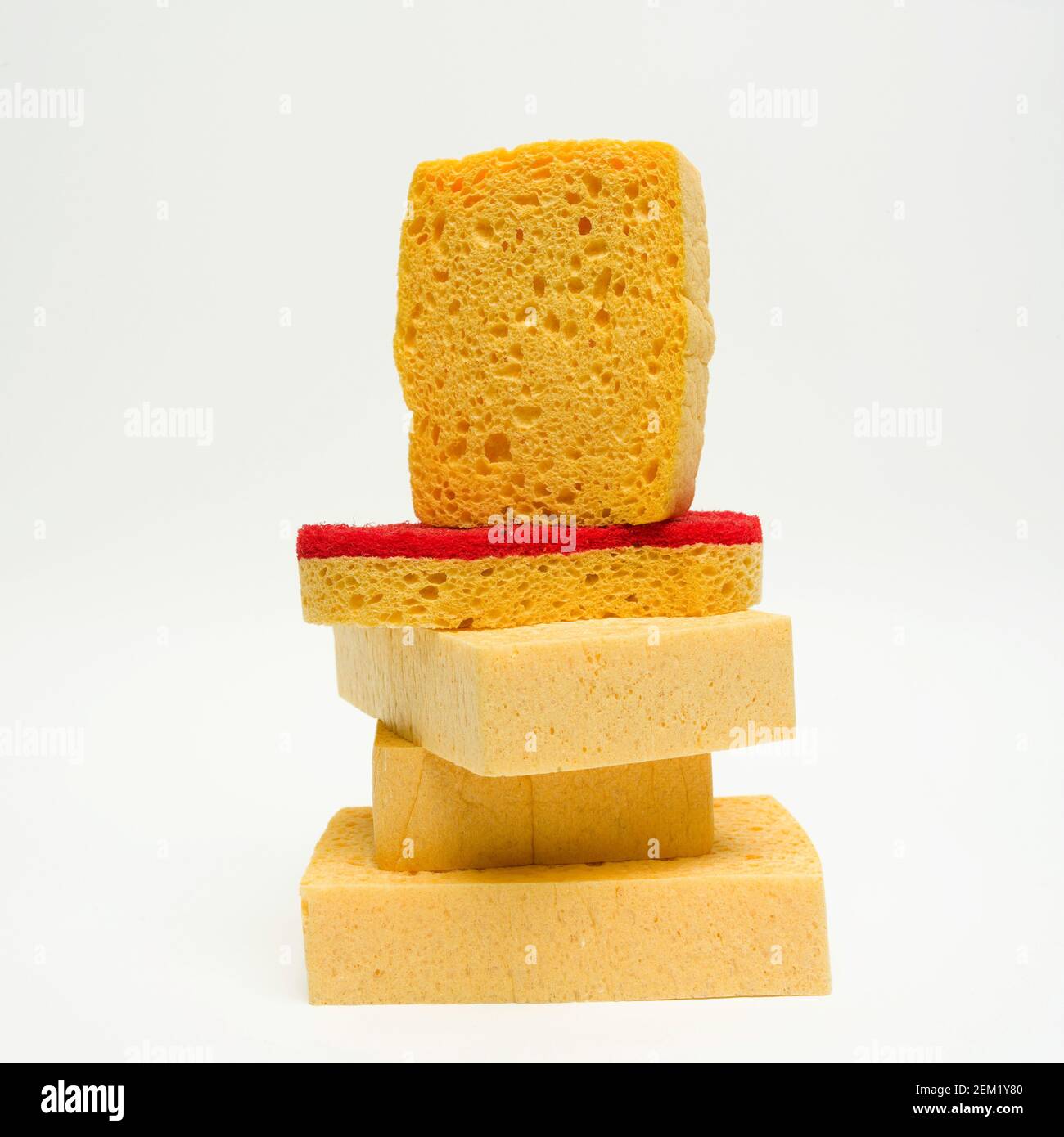 Una vivace pila di spugne da cucina dai colori giallo e rosso su uno sfondo minimalista Foto Stock