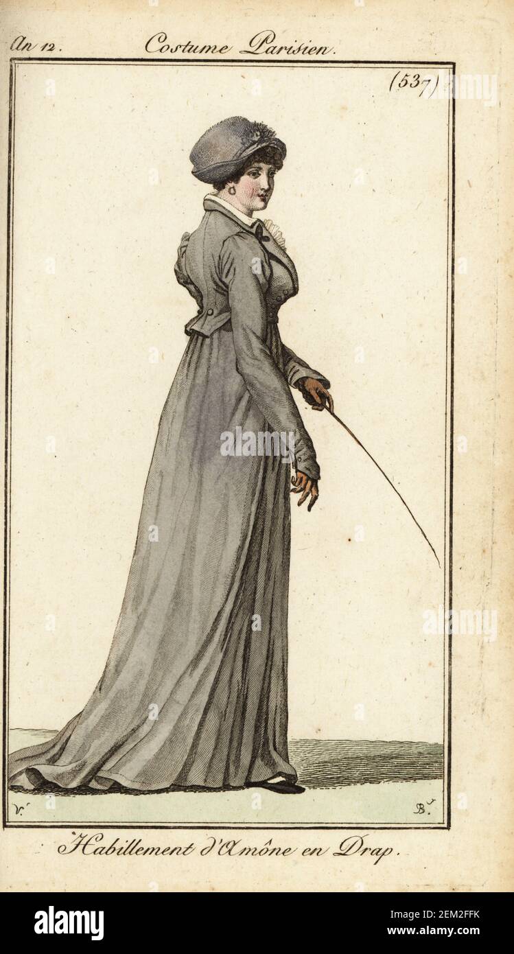 Donna in outfit da equitazione, Parigi, 1804. Indossa un cofano, un cappotto di lana, guanti in pelle e tiene un raccolto da cavalcare. Habillement d'amône en drap. Incisione a mano su copperplate di Pierre-Charles Baquoy dopo Carle Vernet dal Journal des Dames et des Modes di Pierre de la Mesangere, Magazine of Women and Fashion, Parigi, AN 12, 1804. Foto Stock