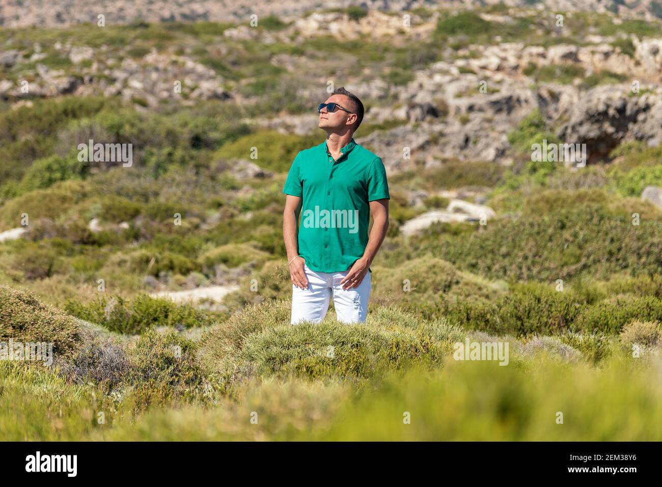 Ragazzo felice in un campo verde in shorts e una camicia. Foto Stock