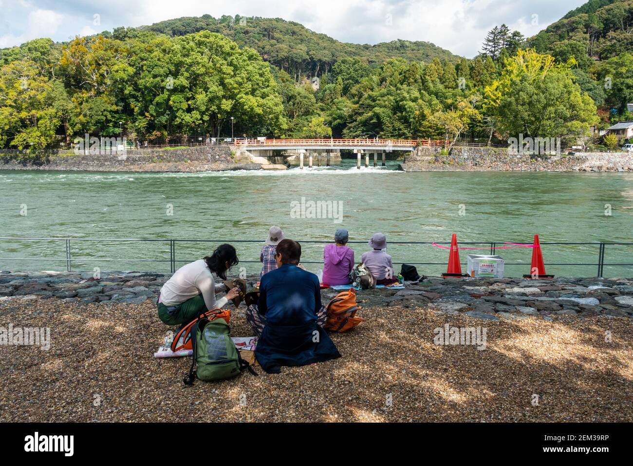 Uji, Giappone - le persone anziane seduto accanto al fiume su una soleggiata giornata autunnale Foto Stock