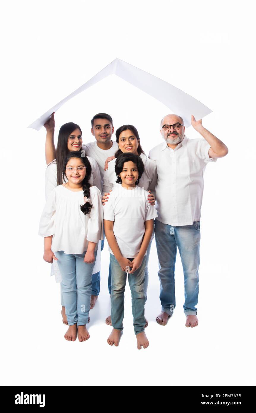Famiglia indiana e concetto immobiliare - multigenerazionale famiglia asiatica tenere modello di casa di carta con tasti su sfondo bianco Foto Stock