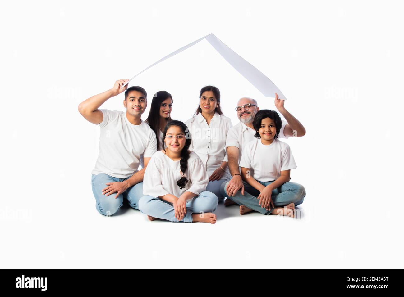 Famiglia indiana e concetto immobiliare - multigenerazionale famiglia asiatica tenere modello di casa di carta con tasti su sfondo bianco Foto Stock
