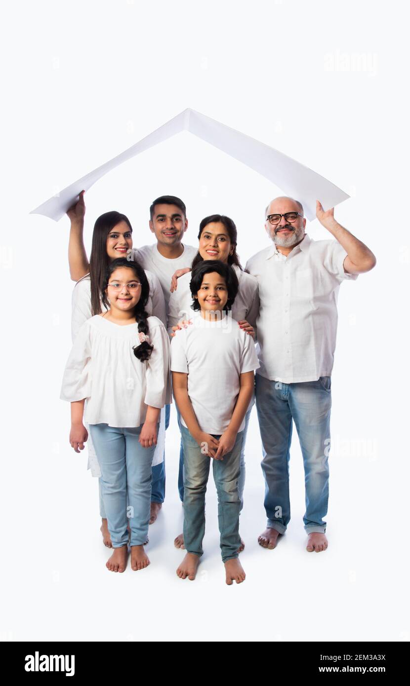 Famiglia indiana e concetto immobiliare - multigenerazionale famiglia asiatica tenere modello di casa di carta con tasti su sfondo bianco Foto Stock