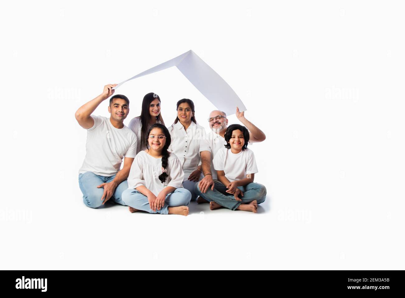 Famiglia indiana e concetto immobiliare - multigenerazionale famiglia asiatica tenere modello di casa di carta con tasti su sfondo bianco Foto Stock