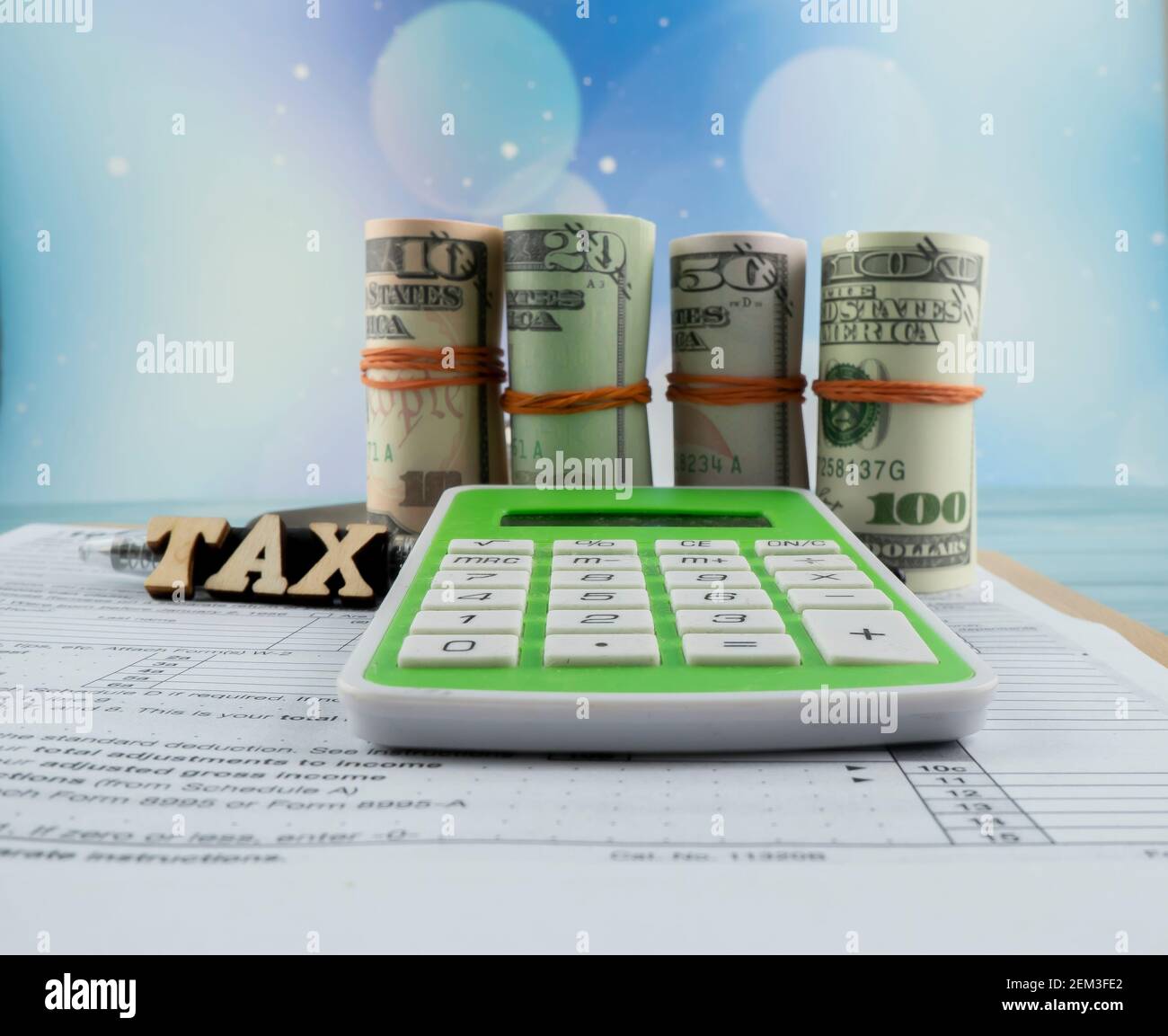 Concetto di riempimento delle imposte - ‘tempo di imposta’, denaro falso, e una calcolatrice con la metà del modulo US IRS 1040. Foto Stock