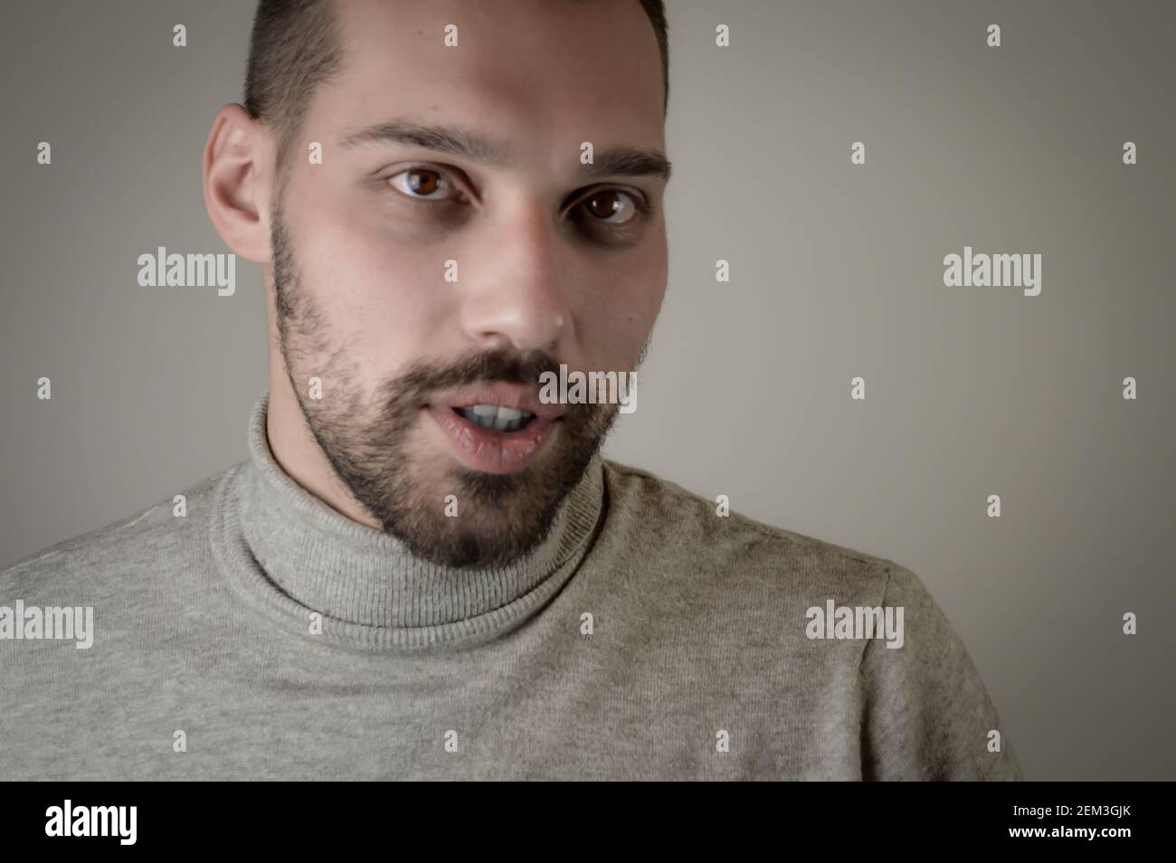 Ritratto di un giovane con una barba corta che sembra sorpreso Foto Stock