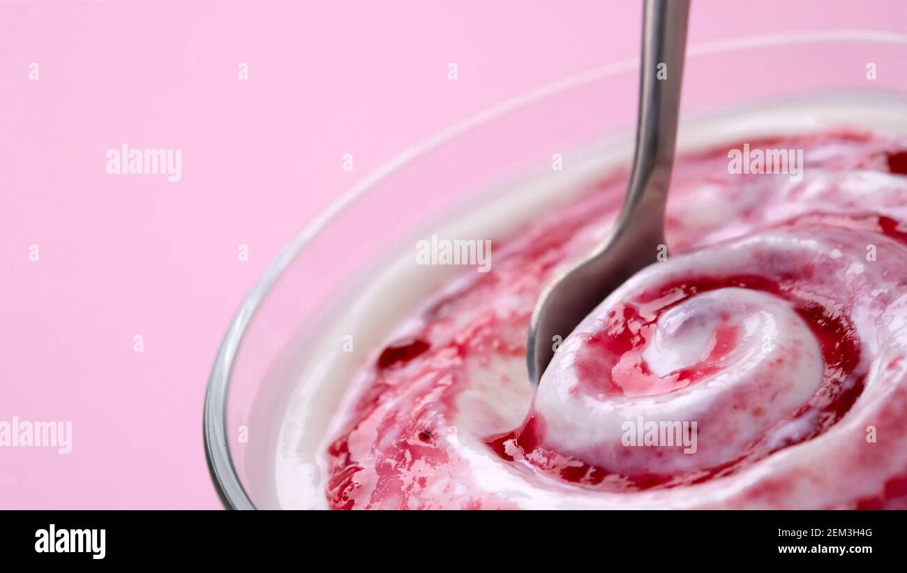 Yogurt con marmellata di frutti di bosco in cucchiaio, panna montata al mirtillo Foto Stock