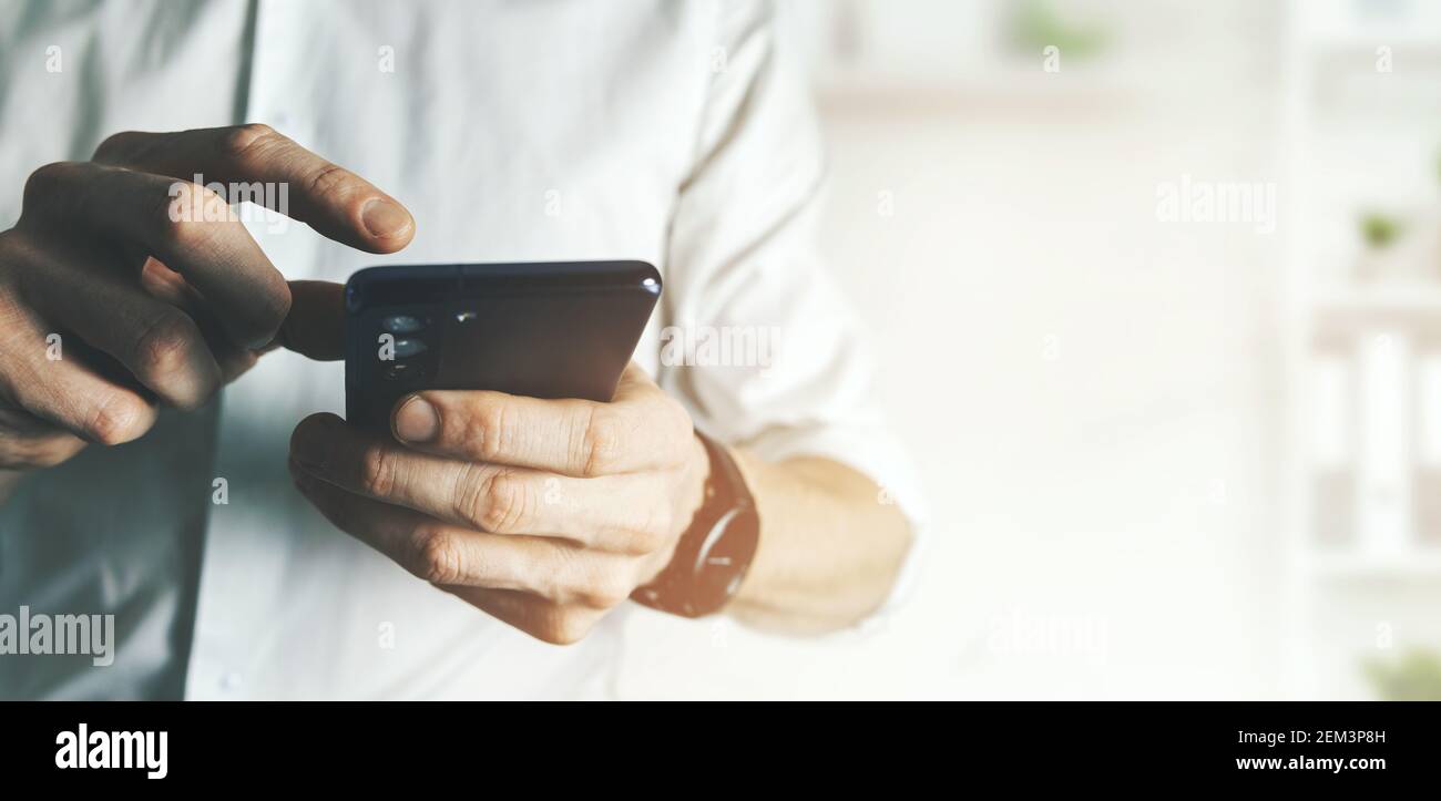 uomo d'affari che usa lo smartphone in ufficio. concetto di comunicazione e tecnologia. spazio di copia del banner Foto Stock