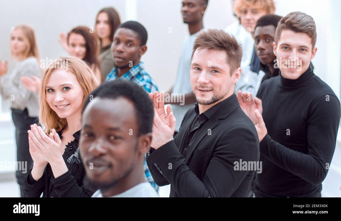 un grande gruppo di giovani diversi si applaude insieme. Foto Stock