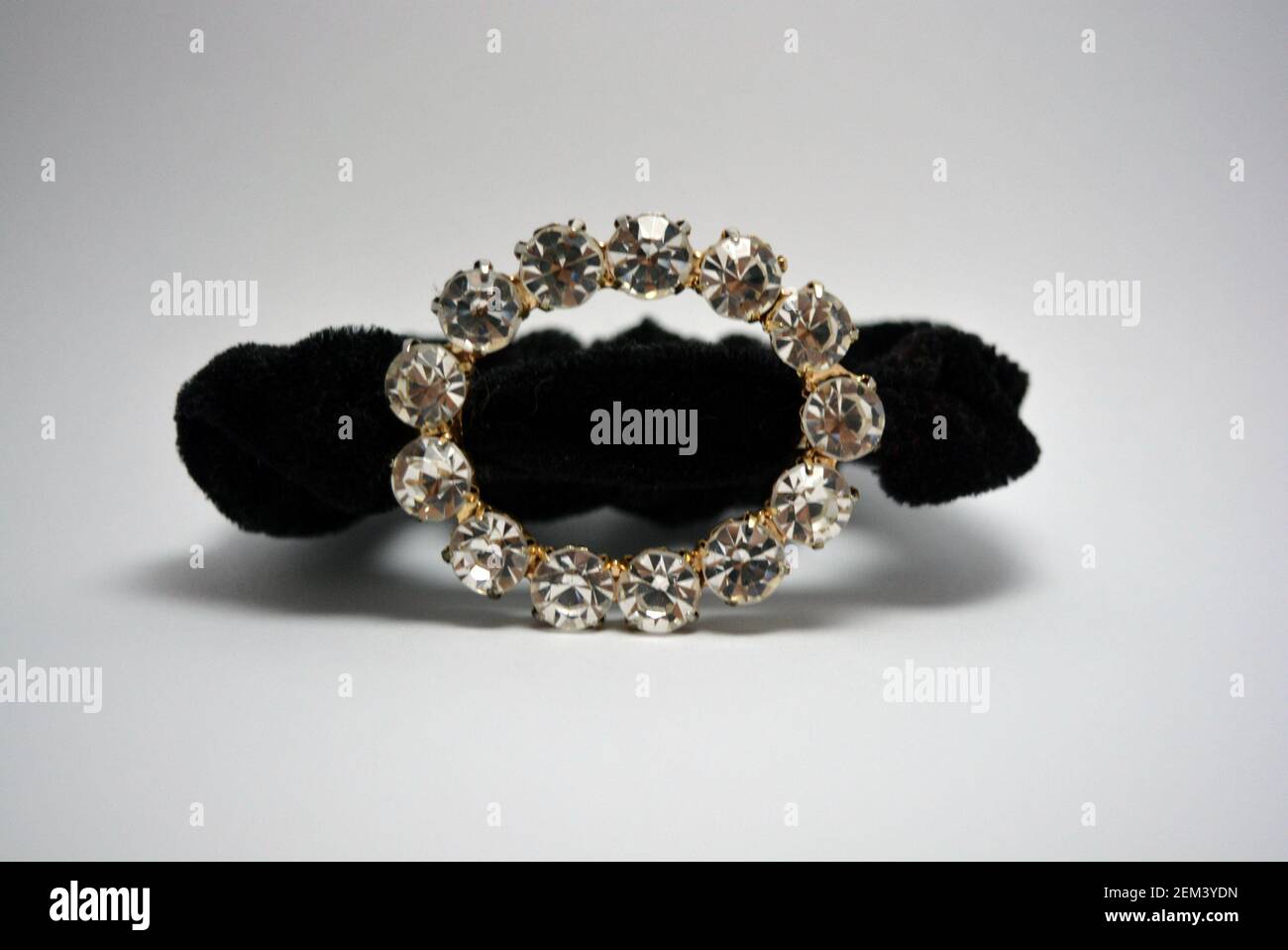 Bella, elegante capigliatura femminile, accessorio per capelli, cravatta nera con grandi pietre bianche. Cerchio di metallo con pietre annegate, gioielli semi-preziosi. Foto Stock