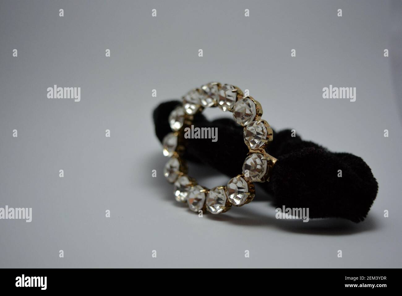 Bella, elegante capigliatura femminile, accessorio per capelli, cravatta nera con grandi pietre bianche. Cerchio di metallo con pietre annegate, gioielli semi-preziosi. Foto Stock