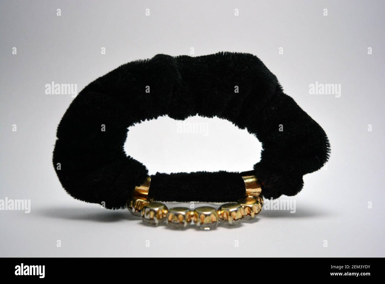 Bella, elegante capigliatura femminile, accessorio per capelli, cravatta nera con grandi pietre bianche. Cerchio di metallo con pietre annegate, gioielli semi-preziosi. Foto Stock