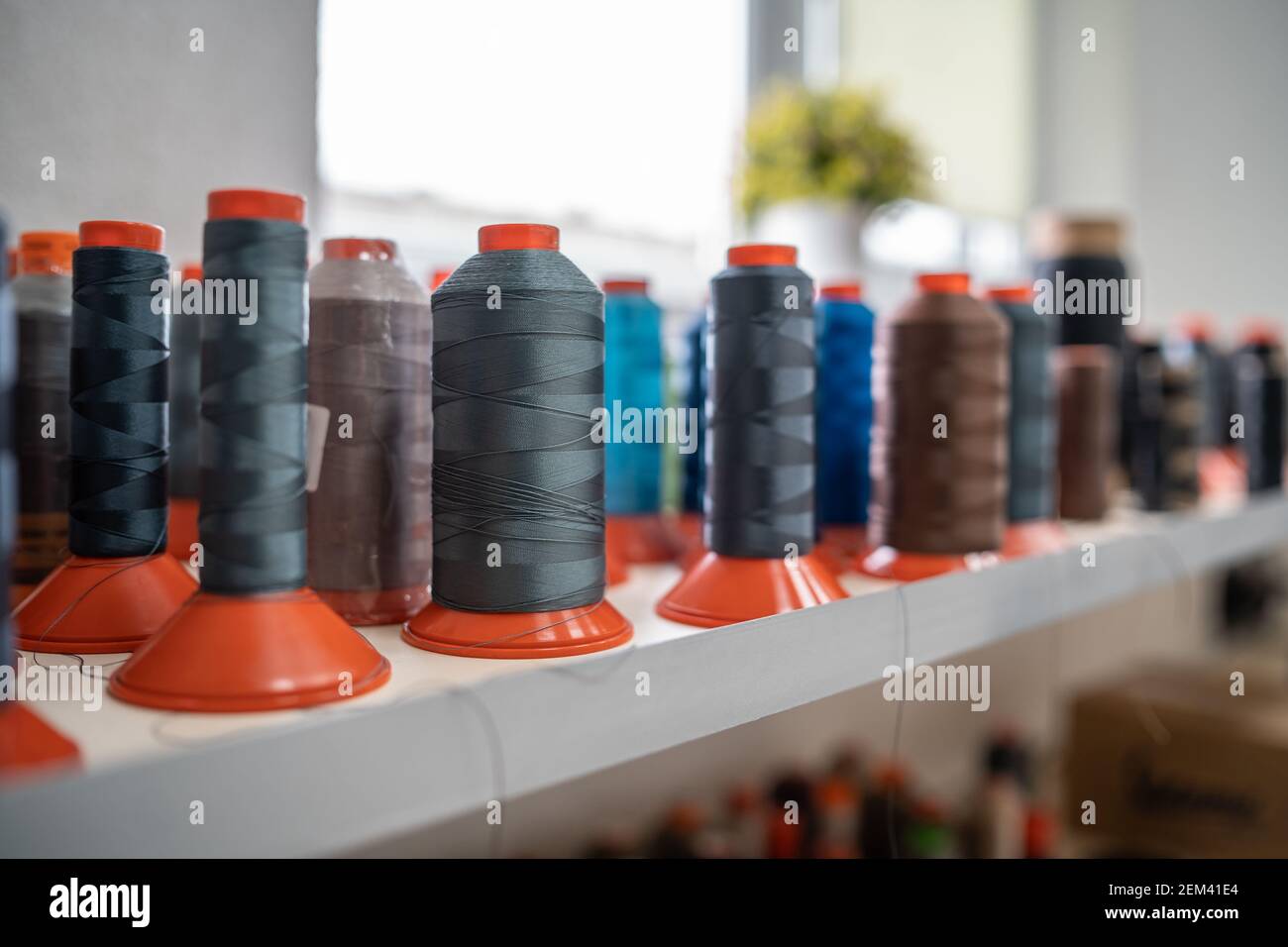 stucchiatura di filo da cucire colorato su tessuto o abbigliamento fabbrica o fabbricazione Foto Stock