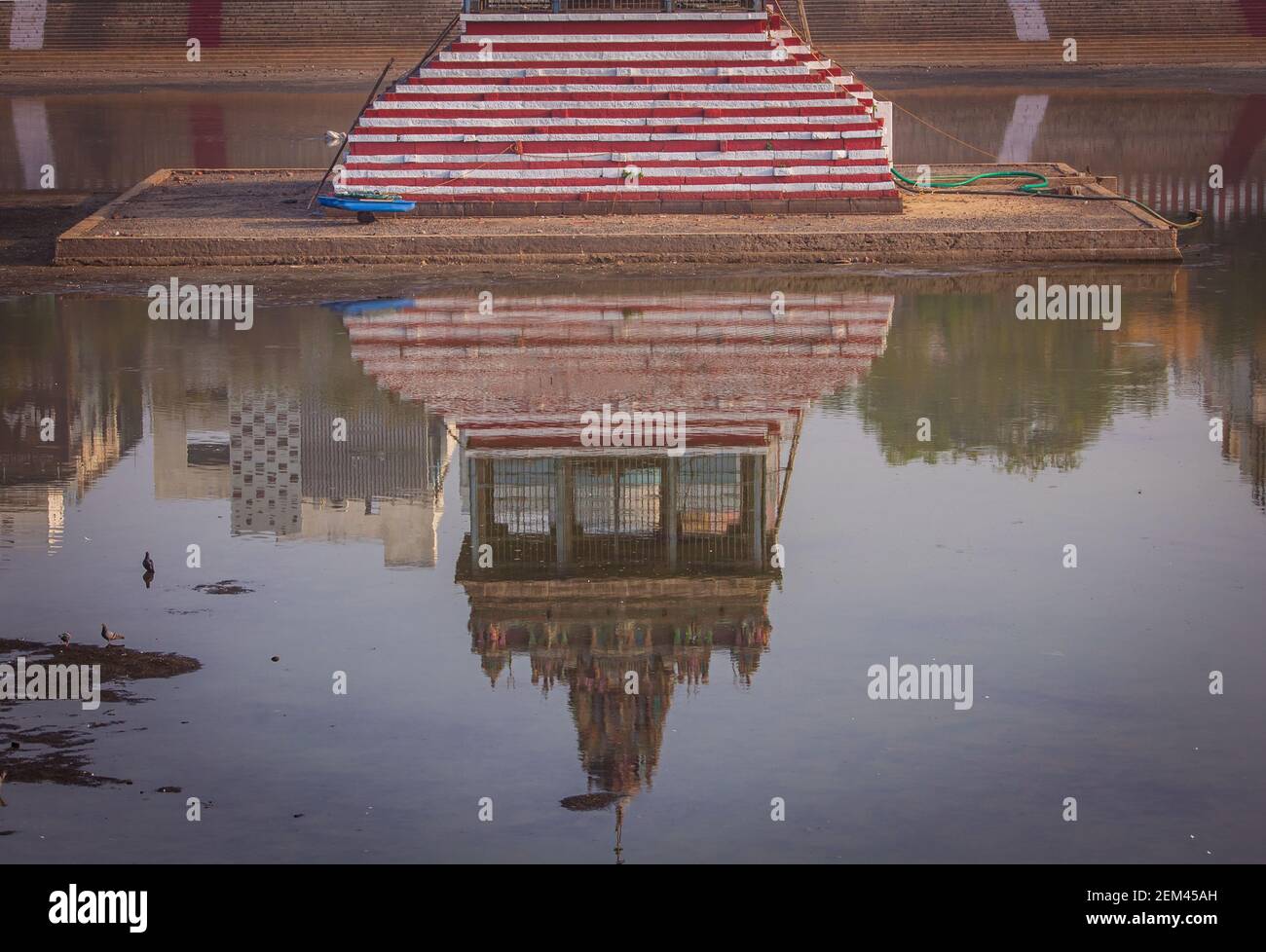 Riflessione della torre del tempio nel serbatoio del tempio che immagazzina acqua Foto Stock