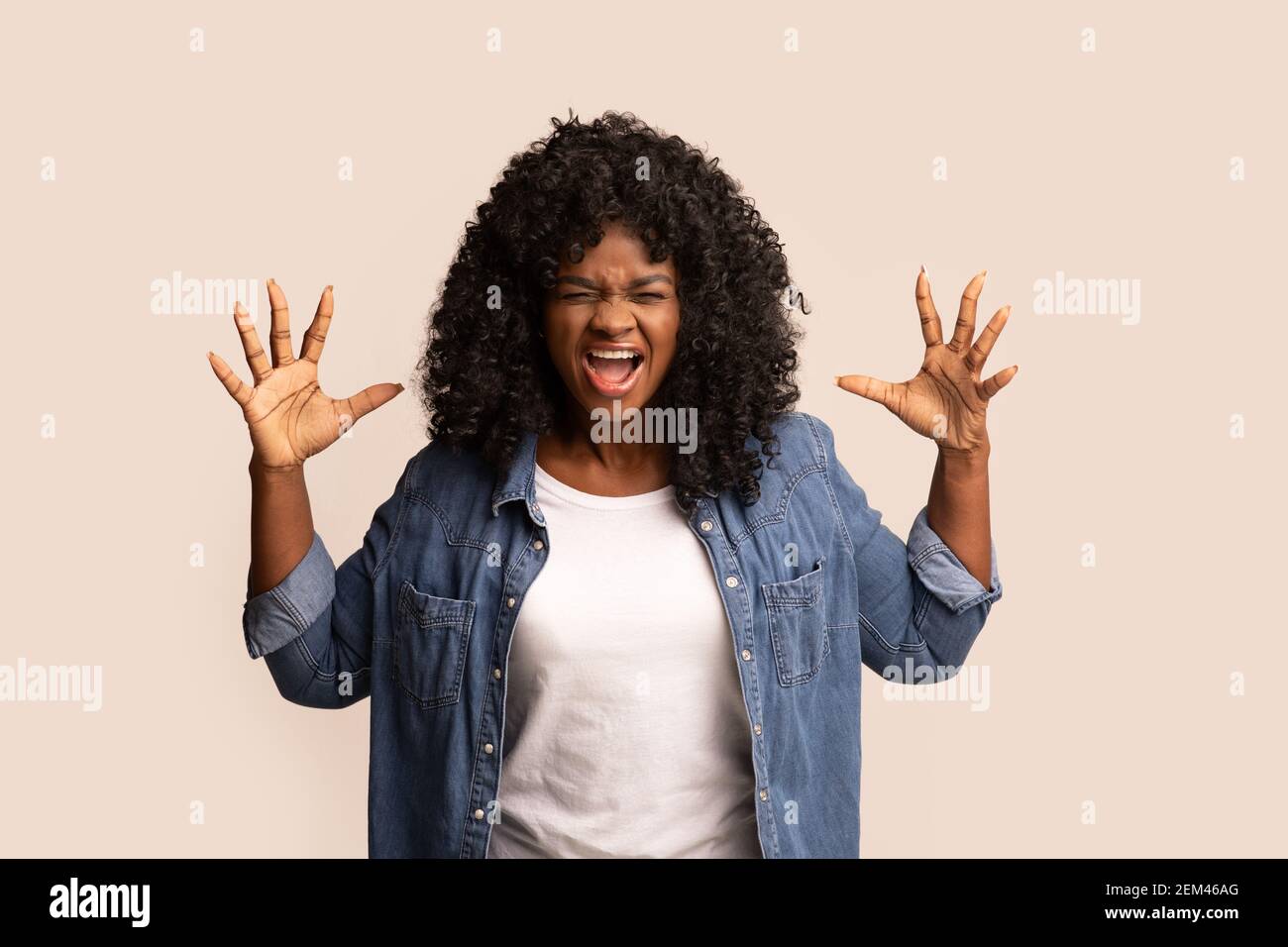 Furiosa donna nera alzando le mani e urlando Foto Stock