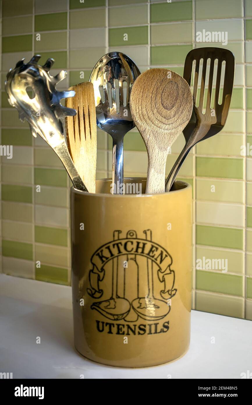Utensili da cucina in una pentola di ceramica - cucchiaio di legno, spatola  e utensili in acciaio inox utilizzati per cucinare gli alimenti Foto stock  - Alamy