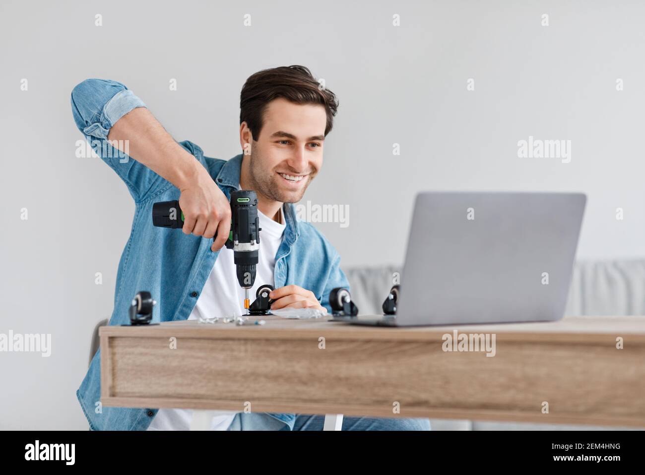 Assemblare i mobili con le proprie mani e la moderna ristrutturazione della casa durante covid Foto Stock