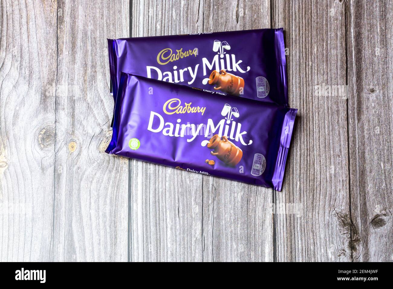 Due bar di cioccolato al latte Cadbury Dairy su un tavolo di legno Foto Stock