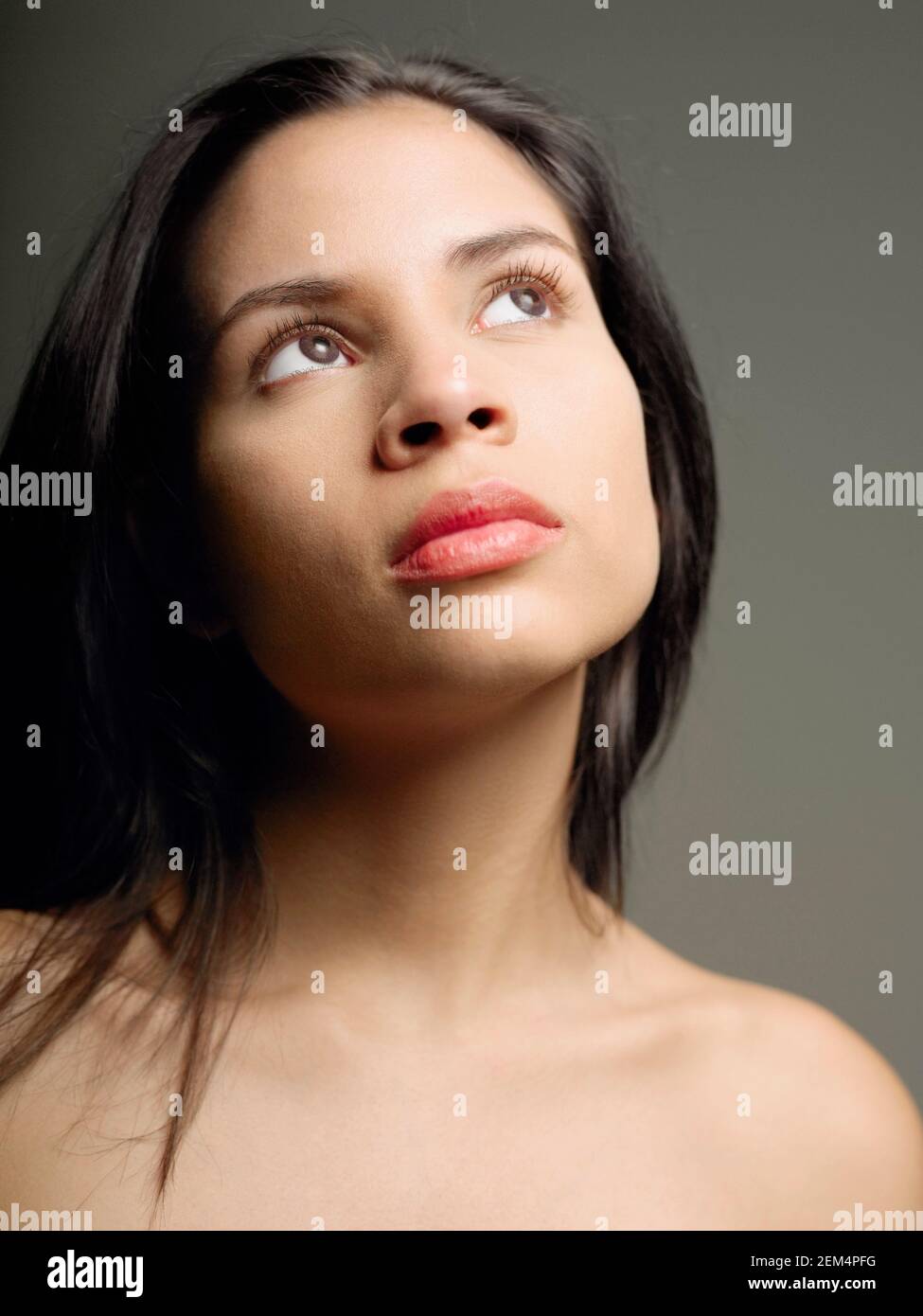 Close-up di una giovane donna che guarda verso l'alto Foto Stock