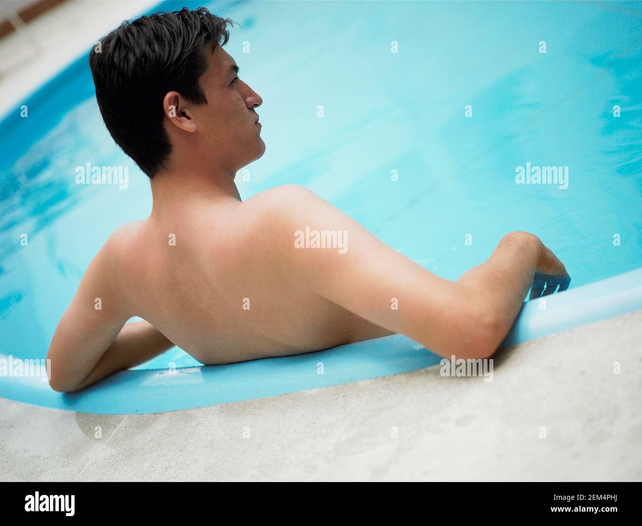 Vista posteriore di un giovane in piscina Foto Stock