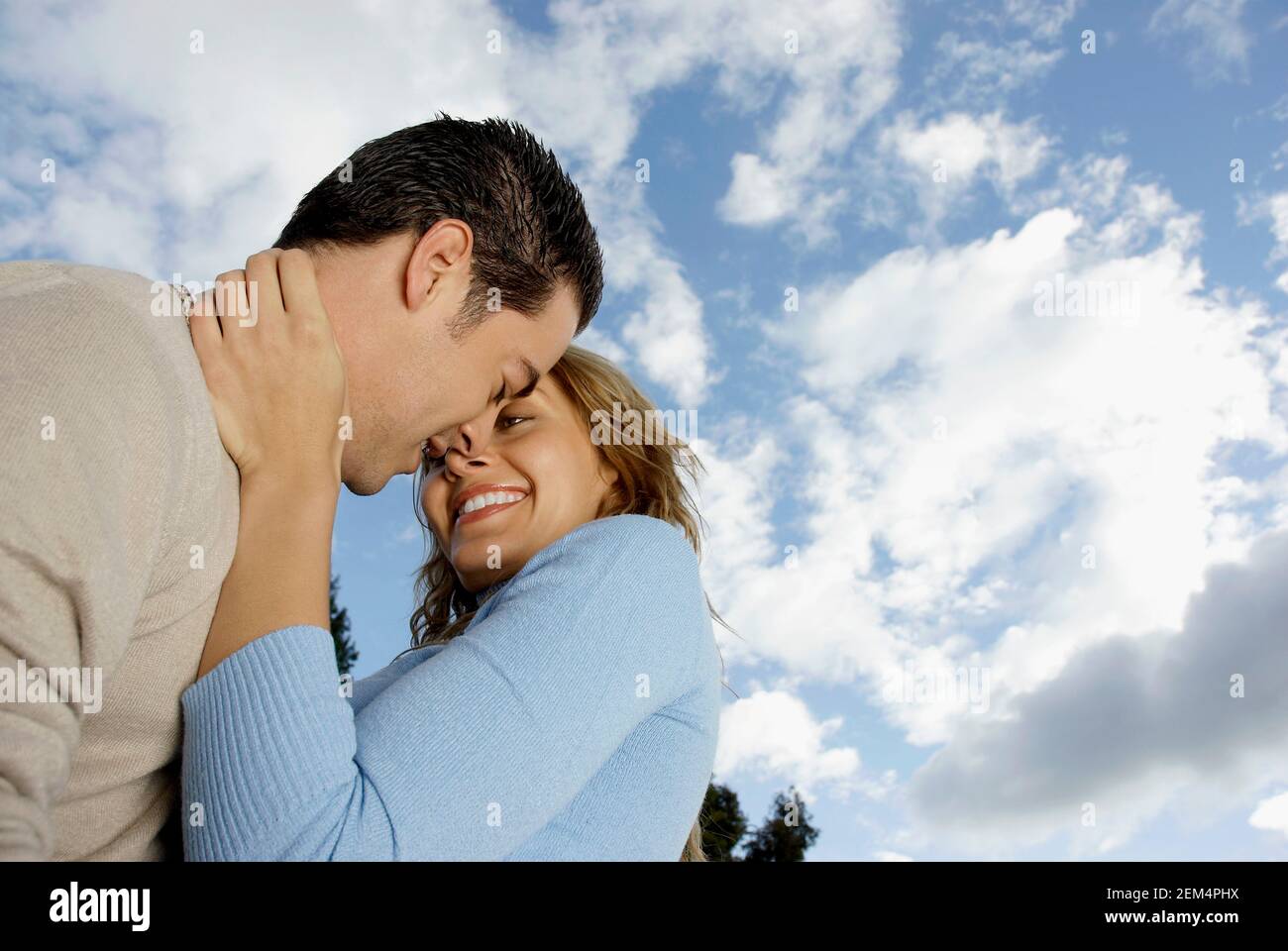 Basso angolo vista di una giovane coppia che abbraccia ogni altro Foto Stock