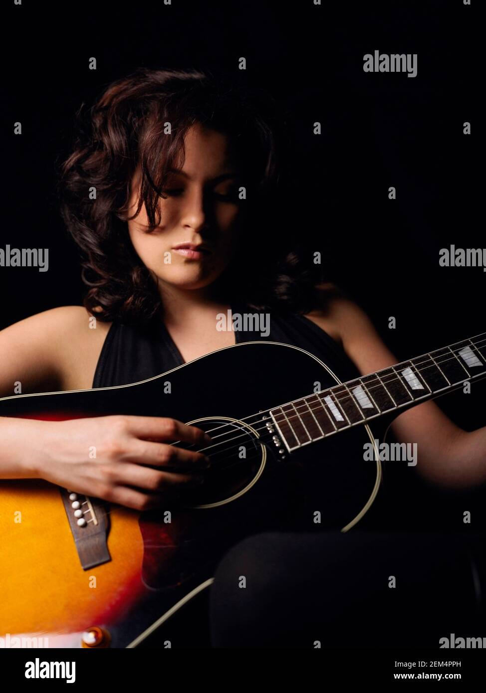 Close-up di una giovane donna a suonare la chitarra Foto Stock