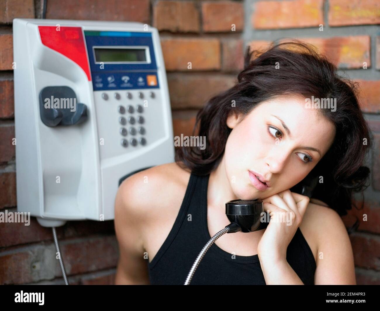 Close-up di una giovane donna che utilizza un telefono a pagamento Foto Stock