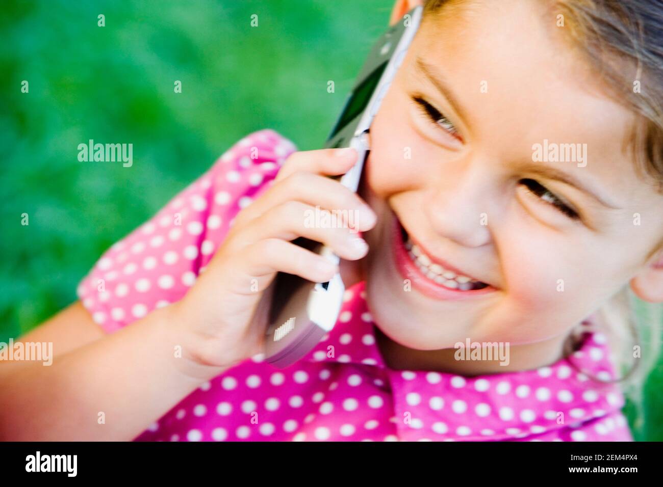 Primo piano di una ragazza che sorride e parla su un cellulare telefono Foto Stock