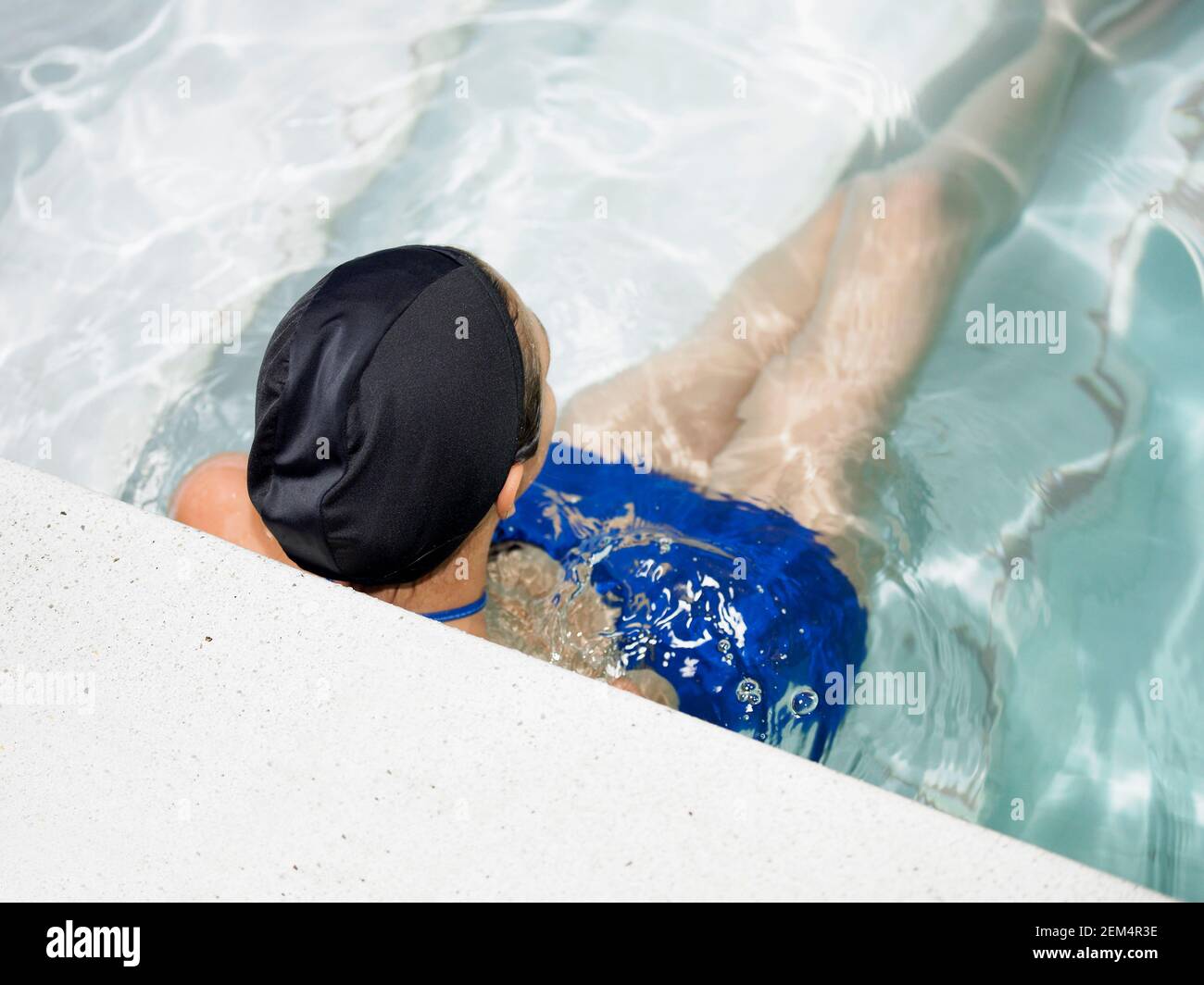 Vista posteriore di un giovane in piscina Foto Stock