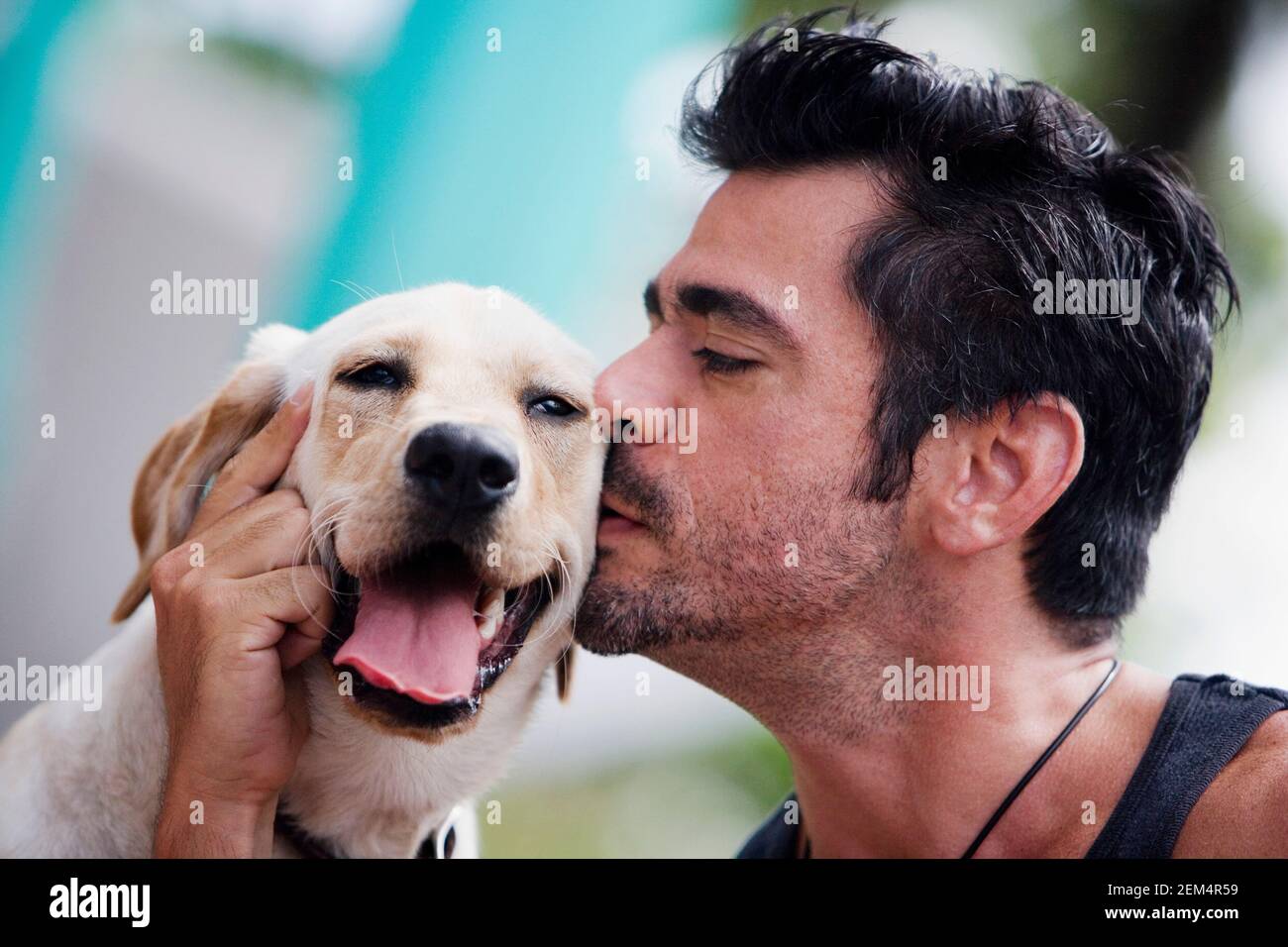 Primo piano di un uomo medio adulto che baciava un cane Foto Stock