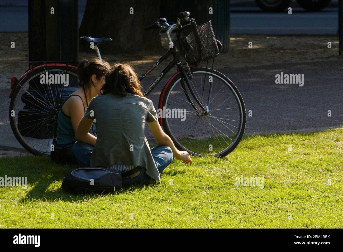 Due donne che siedono sull'erba in un parco Foto Stock