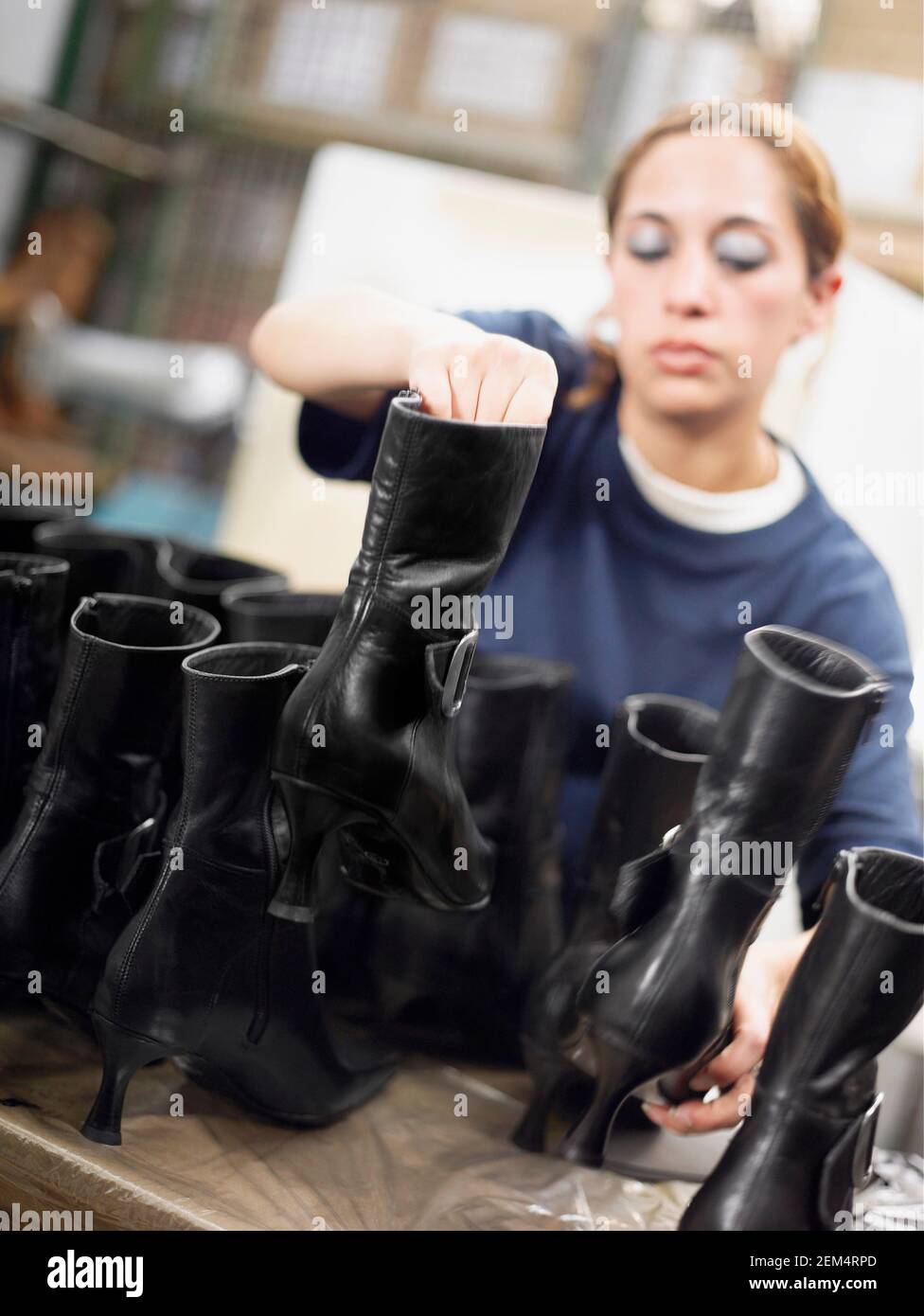 Giovane donna che lavora in una fabbrica di scarpe Foto Stock