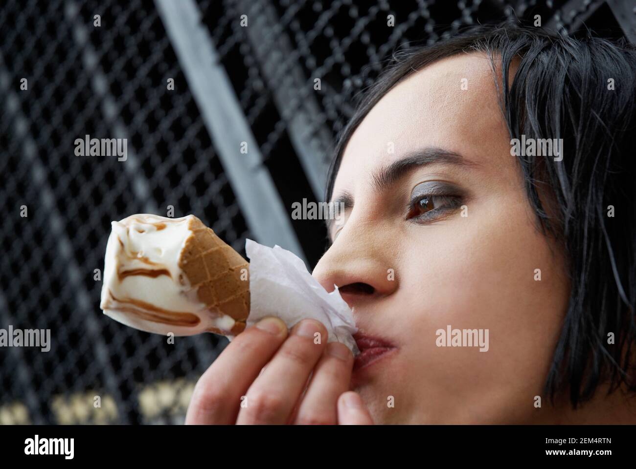 Close-up di un giovane uomo di mangiare un cono gelato Foto Stock