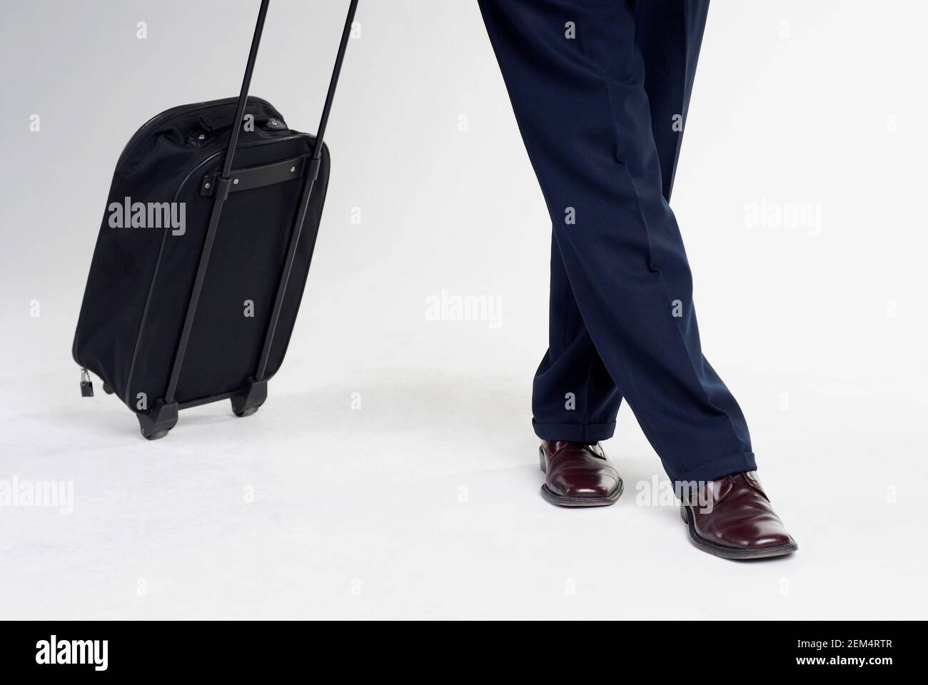 Bassa vista in sezione di un uomo in piedi con la valigia Foto Stock