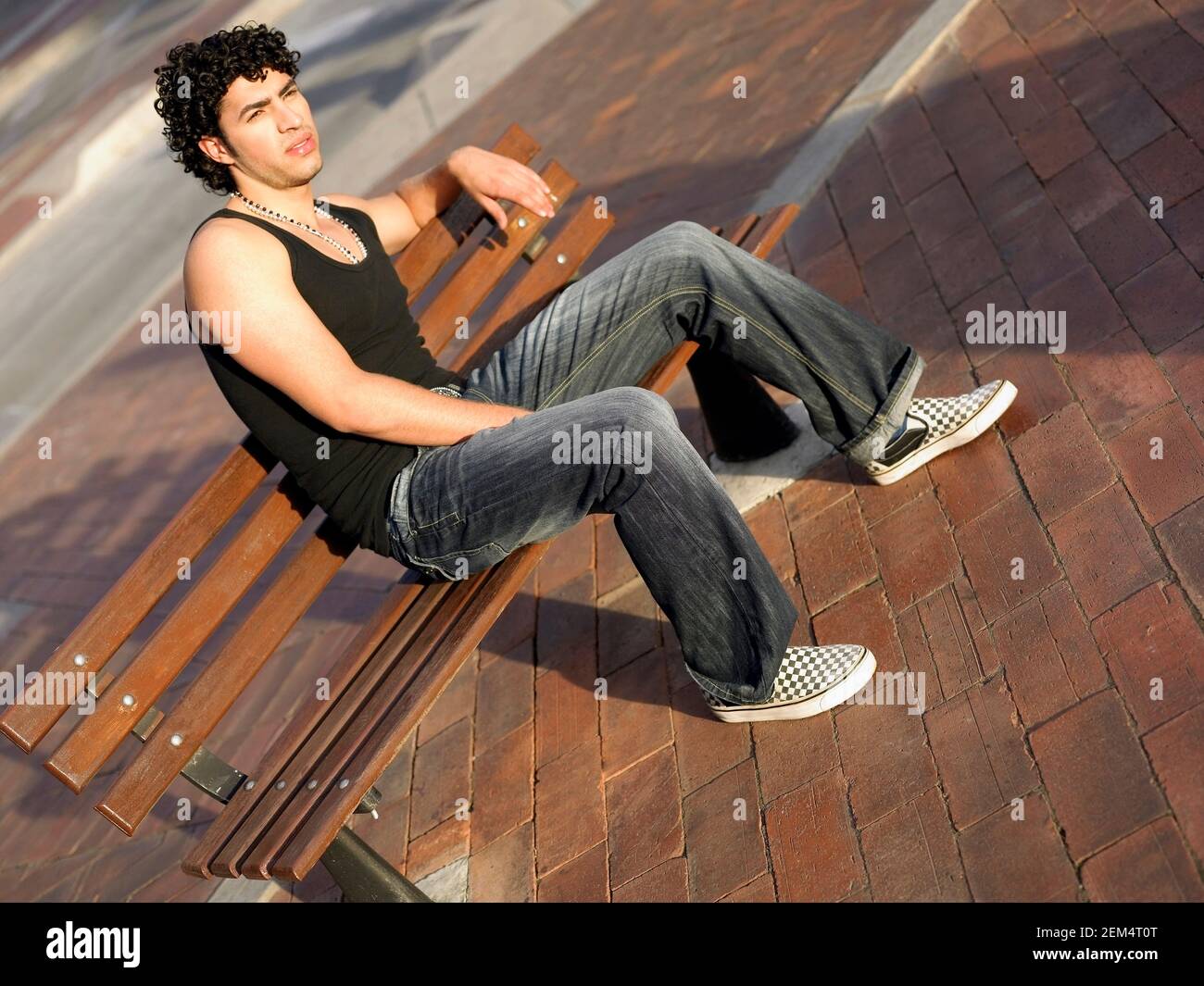 Giovane uomo seduto su un banco di lavoro Foto Stock