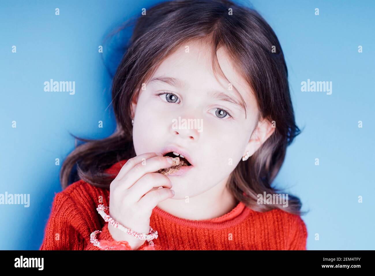 Primo piano di una ragazza che mangia un cioccolato Foto Stock