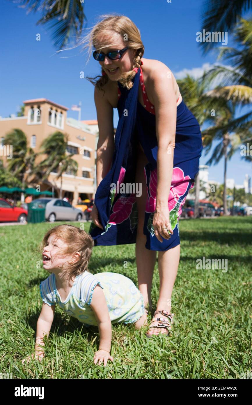 Donna mid adulta che gioca con sua figlia e sorridente Foto Stock