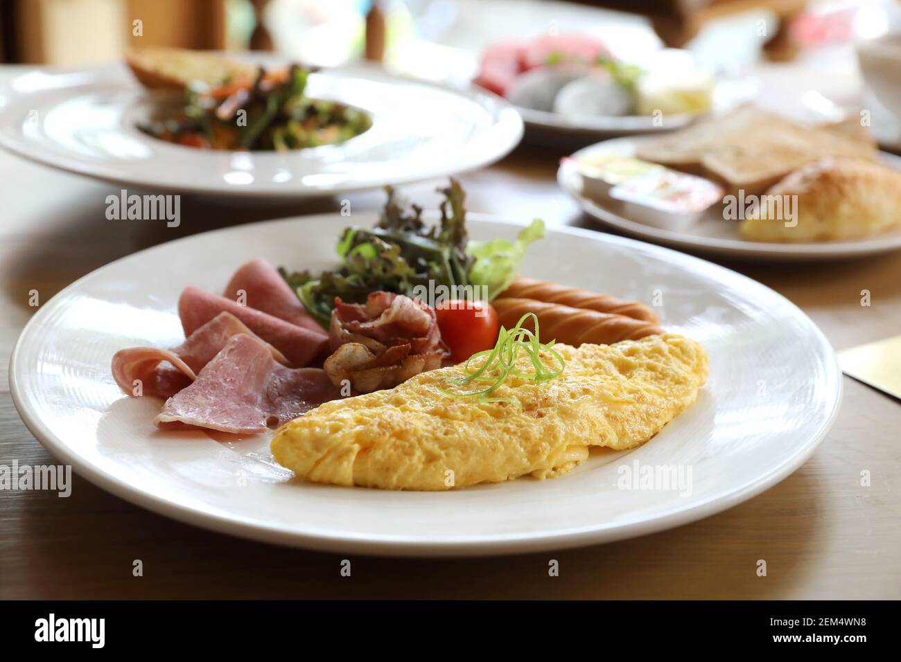 Set colazione frittata con salsicce e pancetta insalata su uno sfondo di legno Foto Stock