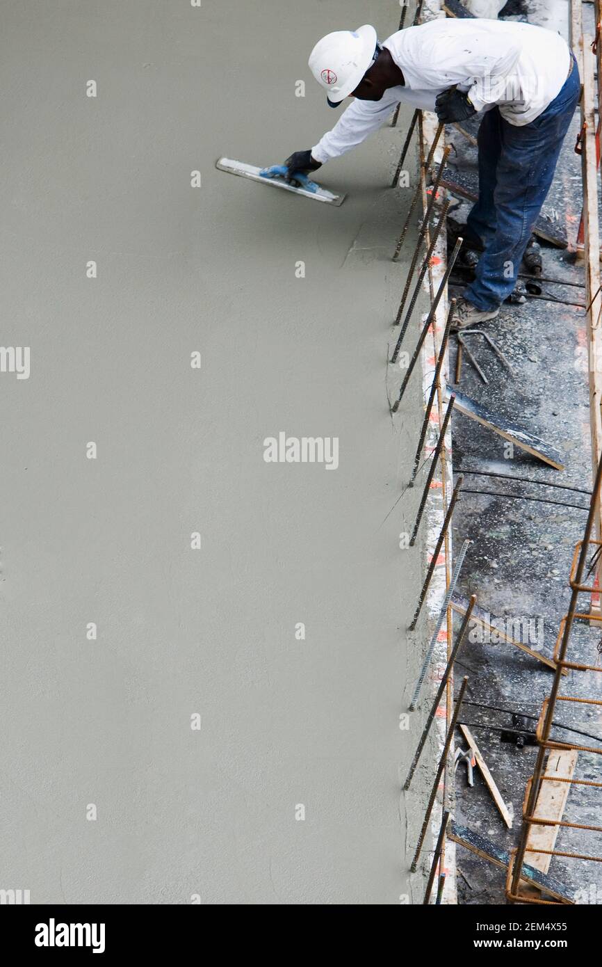 Elevato angolo di visione di un lavoratore edile lavorando presso un sito in costruzione Foto Stock