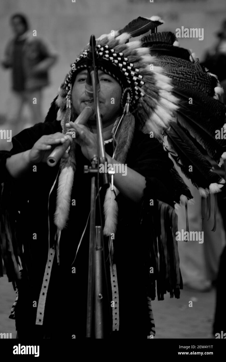 Primo piano di un uomo rosso indiano che tiene un flauto dentro parte anteriore di un microfono Foto Stock