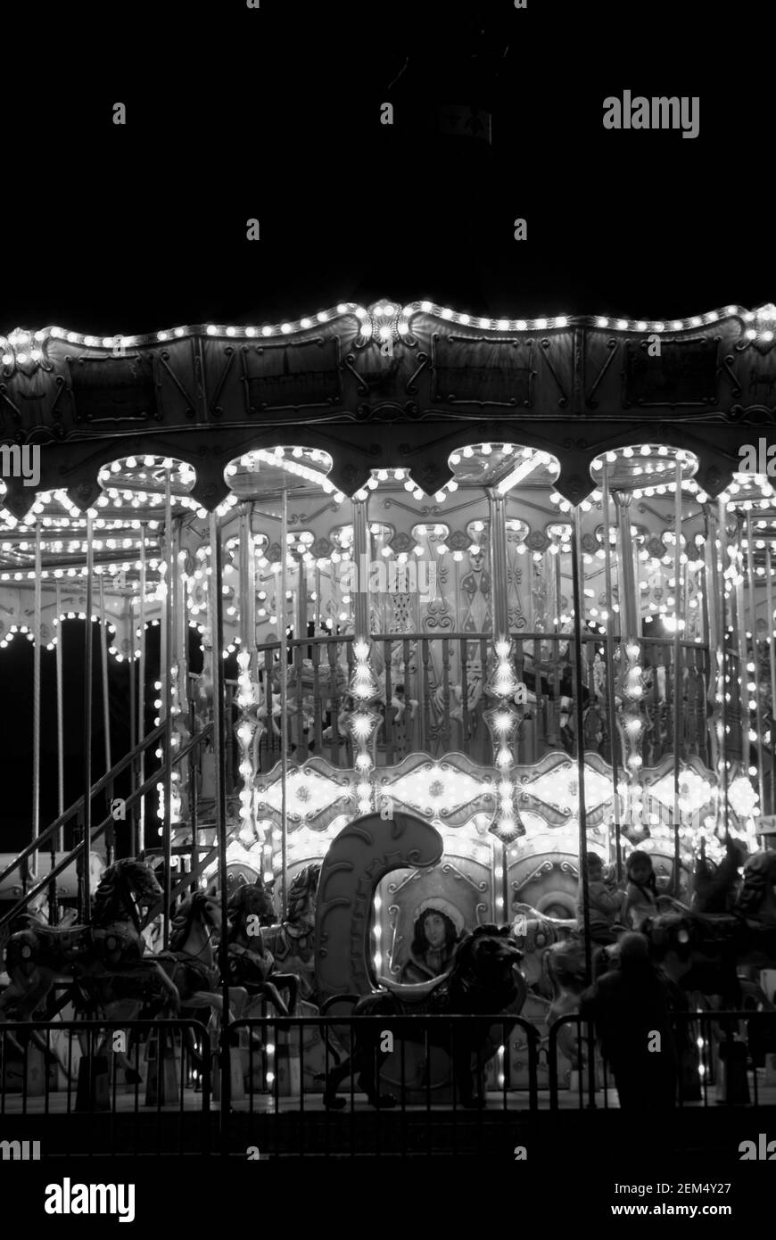 Cavalli a carosello in un parco divertimenti illuminato di notte Foto Stock