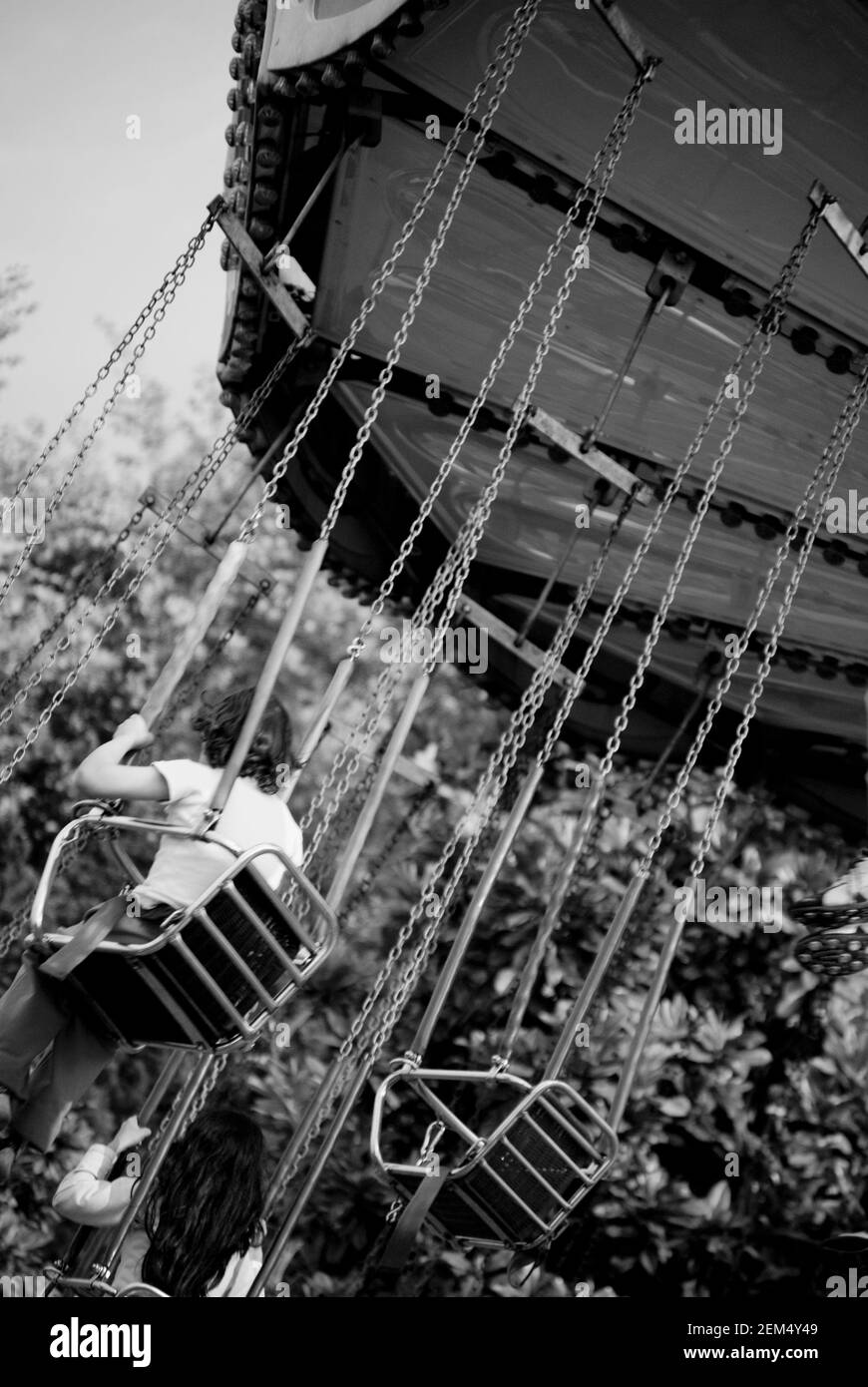 Vista posteriore di un ragazzo con una ragazza su a. corsa di rotazione della catena Foto Stock