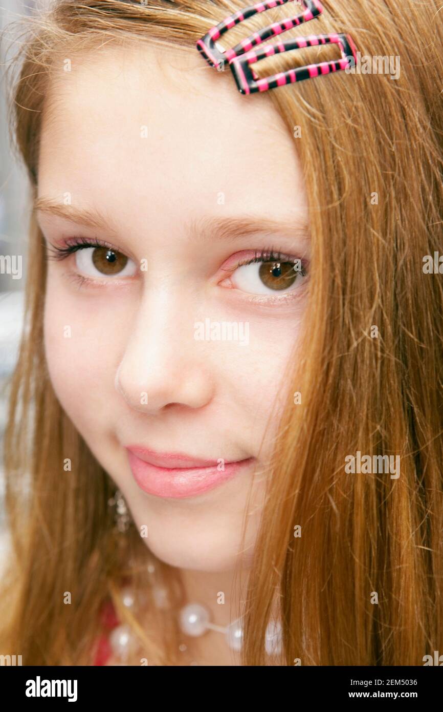 Ritratto di una ragazza adolescente con un capello agganciato i suoi capelli Foto Stock